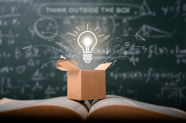 Think outside the box on a green blackboard. Startup, educational concept. Sparking creative ideas, change and growth.